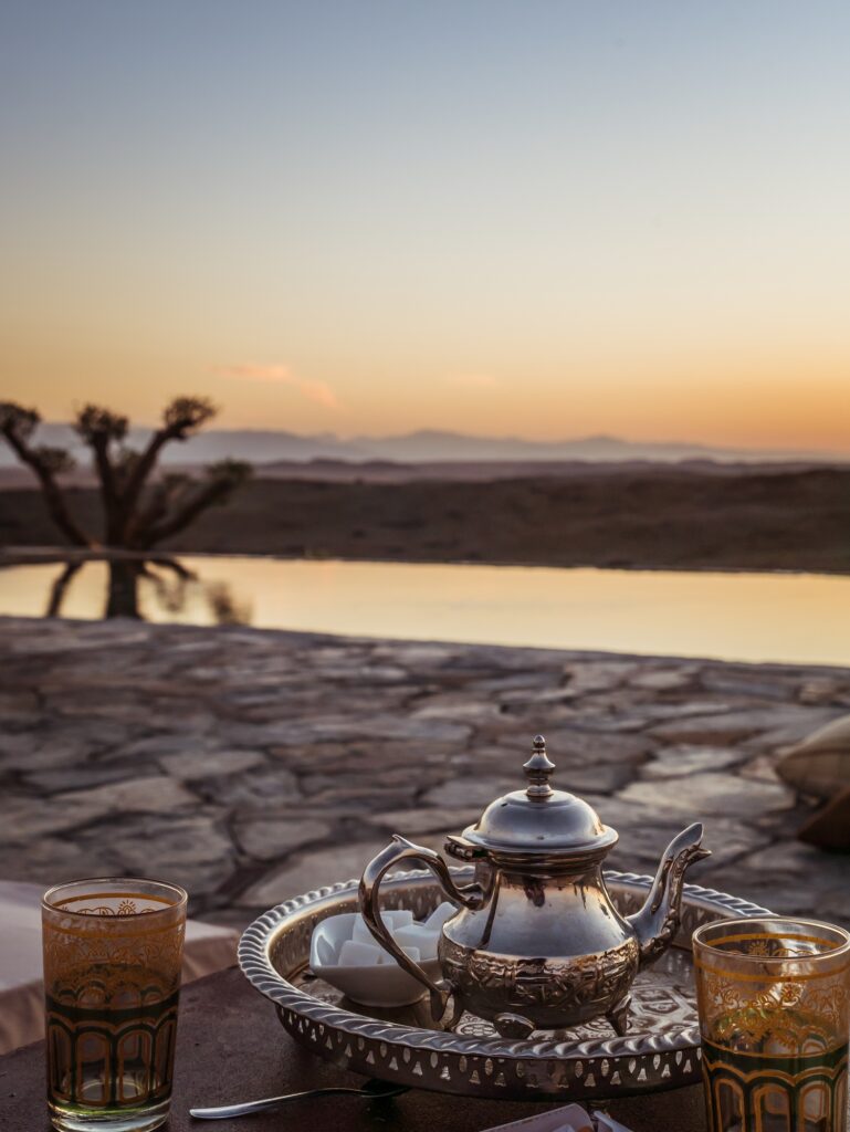 Vertical closeup shot of a typical Moroccan mint tea set on the table in Agafay desert, Marrakech